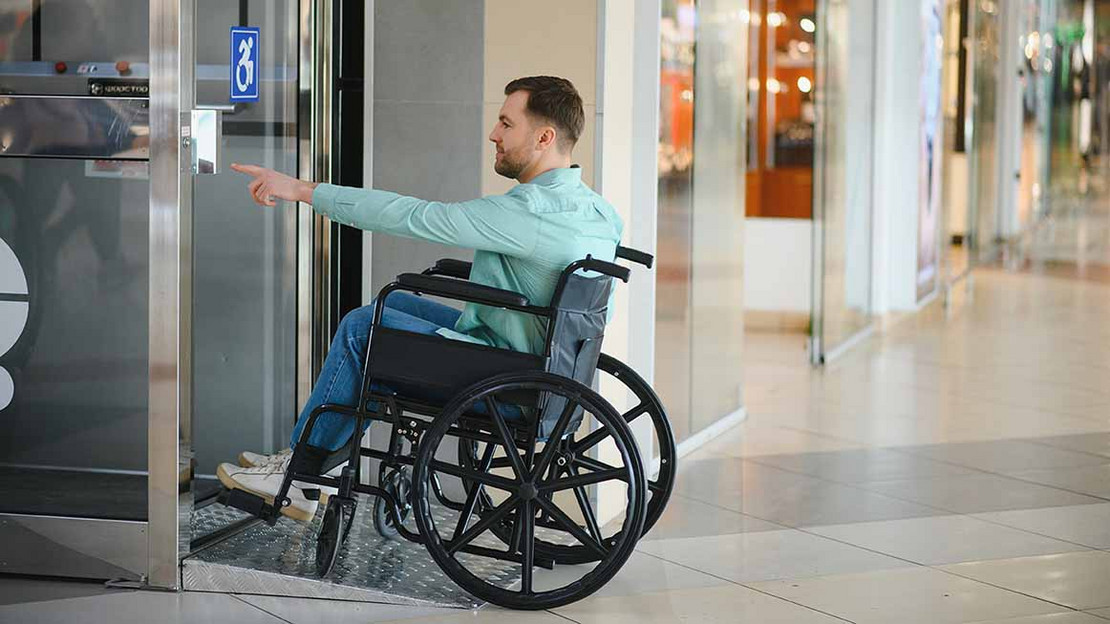 Mann in einem Rollstuhl wartet vor einem Rollstuhl. 