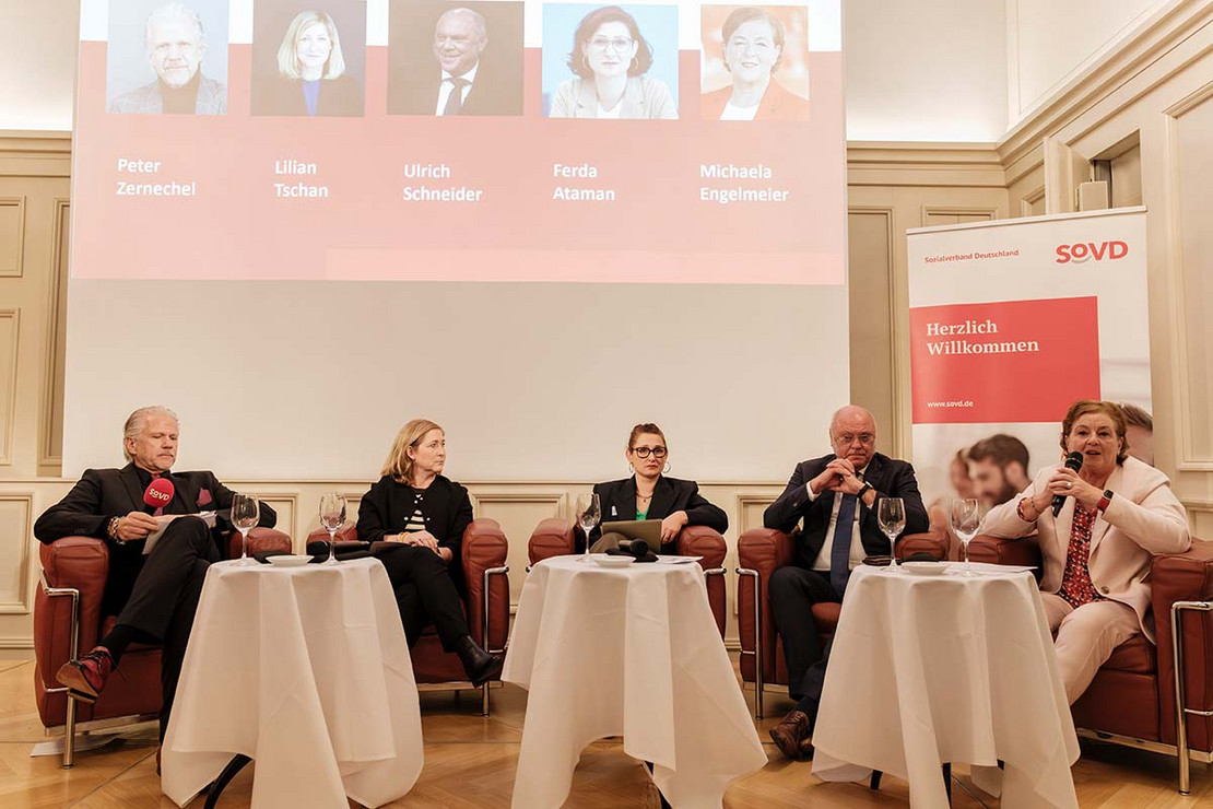 Fünf Personen sitzen auf Sesseln in einem Halbkreis.